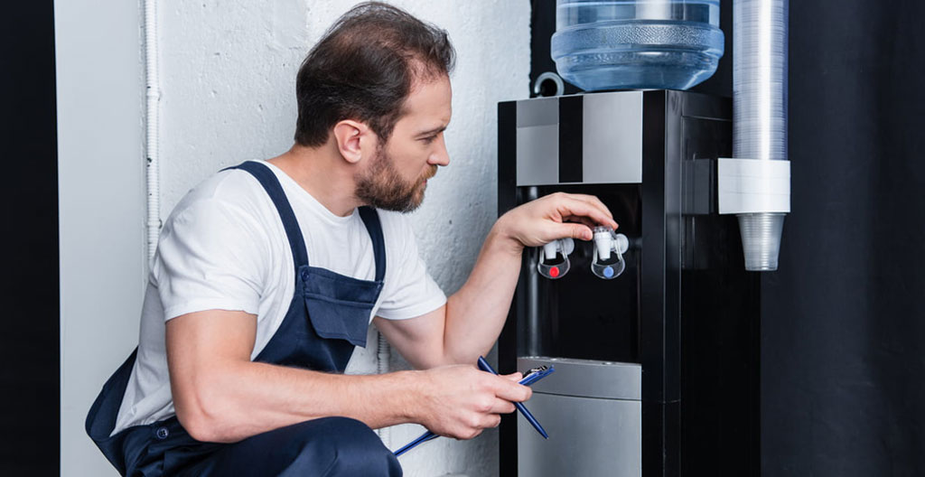 Gros plan sur gouttes d'eau cristallines tombant dans un verre transparent, eau fraîche, reflets lumineux, fond neutre et clair